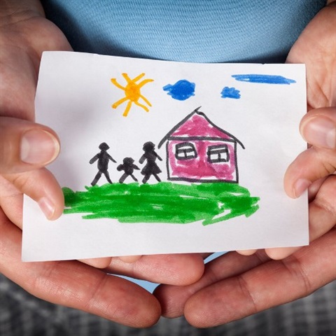Child and parent holding a drawing of a house and family