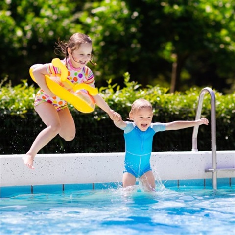 Young children playing in swimming pool